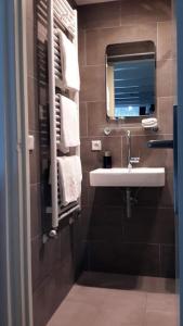 uma casa de banho com lavatório, espelho e toalhas em Bed & Breakfast WestViolet em Amsterdã