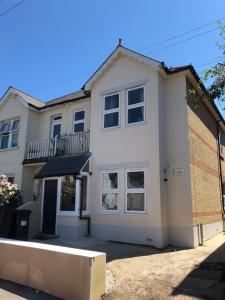 a white house with a fence in front of it at Bournemouth Hot Tub & Sauna Holiday Let in Bournemouth