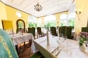 a dining room with white tables and chairs at Schlosshotel Villa Westerberge in Aschersleben