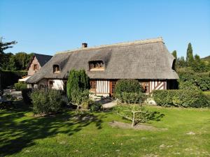 an old house with a thatched roof with a yard at La Griotte & Spa&Piscine in Pennedepie