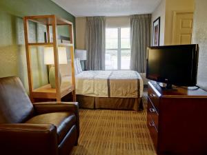 スタッフォードにあるSonesta Simply Suites Staffordのベッドと薄型テレビがあるホテルの部屋