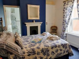 a bedroom with a bed with a blue wall at Summerwind Guest House in Exmouth
