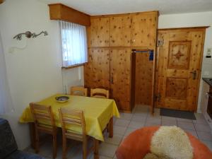 une salle à manger avec une table et des chaises jaunes dans l'établissement Curtins 16, à Pontresina