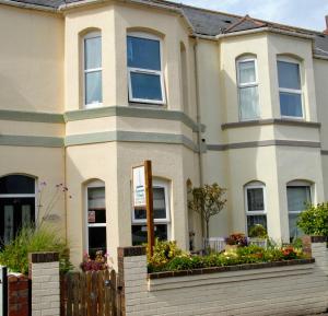 a house with a fence in front of it at Summerwind Guest House in Exmouth