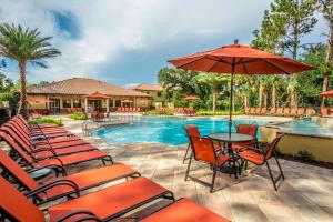 a patio area with chairs, tables and umbrellas at The Fountains Resort Orlando at ChampionsGate in Kissimmee