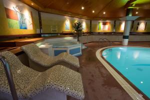 uma grande piscina com cadeiras e uma banheira de hidromassagem em Glenavon House Hotel em Cookstown