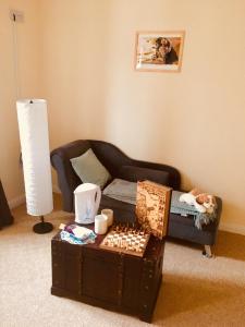 uma sala de estar com uma mesa de xadrez e um sofá em Treasure Box Retreat em Clifden