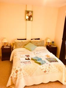 a bed in a bedroom with two nightstands and two lamps at Treasure Box Retreat in Clifden