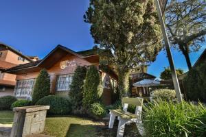 a house with a bench in the front yard at Pousada Solar Viena in Gramado