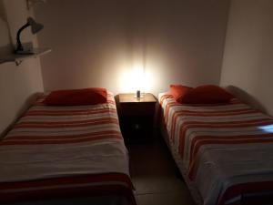 two beds in a room with a lamp on a table at Dream Village,Paradise for families and Kitesurfers in Cumbuco