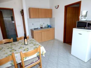 eine Küche mit einem Tisch und einem weißen Kühlschrank in der Unterkunft Apartments Branko Nin in Nin + 37 Fotos