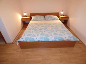 ein Bett in einem Schlafzimmer mit zwei Nachttischen und zwei Lampen in der Unterkunft Apartments Branko Nin in Nin