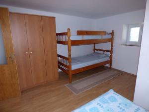 Zimmer mit einem Etagenbett und einem Holzschrank in der Unterkunft Apartments Branko Nin in Nin