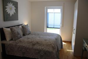 a bedroom with a bed and a window at Chiemsee-Edelweiß Ferienwohnung in Prien am Chiemsee