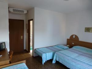 a hotel room with two beds and a tv at Hotel Sole in Rosolina Mare