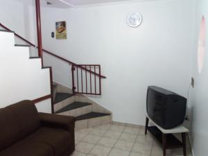 ein Wohnzimmer mit Sofa und Fernseher in der Unterkunft Residencial Castelo Branco II in Campinas