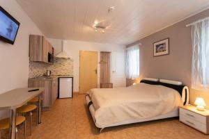a bedroom with a bed and a table and a kitchen at Rinvasta in Druskininkai
