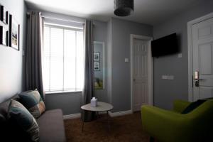 a living room with a couch and a table and a window at Wilde Ballybunion in Ballybunion +20 photos