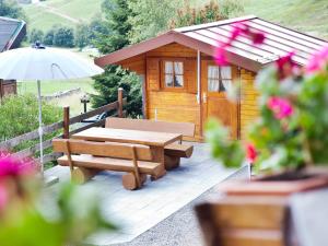 Cabaña de madera con mesa de picnic y sombrilla en Haus Keller Ferienwohnungen en Todtnauberg