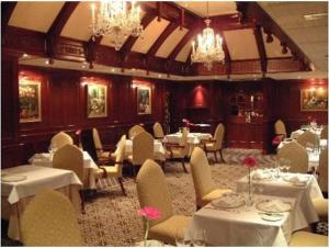 a dining room filled with tables and chairs at Barn Hotel London Ruislip in Hillingdon