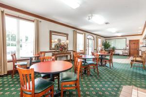 a restaurant with tables and chairs and windows at Plantation Oaks in Millington