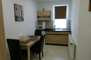 A kitchen or kitchenette at Wolf House Apartman