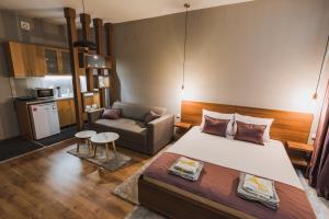 a bedroom with a large bed and a couch at Central Plaza Apartments in Niš
