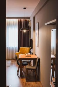 a dining room with a table and chairs in a room at Central Plaza Apartments in Niš