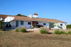 Casa blanca con mesa y sombrilla en Monte da contenda, en Campo Maior