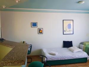 a room with a bed and a desk and a table at Flat Saint Paul Residence in Bauru
