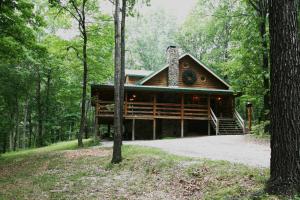 une cabane en rondins au milieu d'une forêt dans l'établissement Silver Ridge Resort, à Eureka Springs