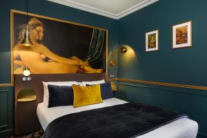 a hotel room with a bed and a painting on the wall at Montparnasse Daguerre in Paris