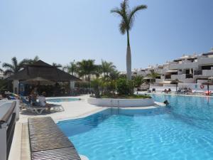 een zwembad in een resort met palmbomen en gebouwen bij Adeje Paradise dreams in Playa Paraiso