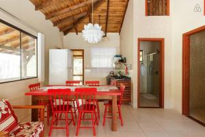 a kitchen with a red dining table and red chairs at Gamboa Luna y Sol Apart-Hotel in Gamboa