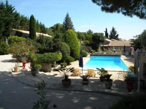 una piscina en un patio con macetas en Mas des Petits Loups, en Cabrières