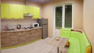 キーウにあるApartment near metro Pozniakyのキッチン(緑の椅子、木製テーブル付)