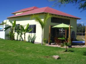 a house with a table and an umbrella in a yard at Villas Premier in Tequisquiapan