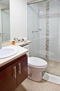 y baño con aseo, lavabo y ducha. en Aparta-Suites Mirador del Recuerdo, en Bogotá