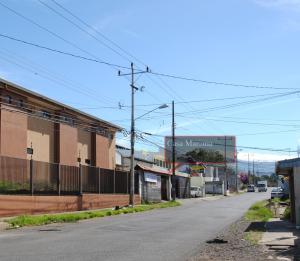 an empty street in a town with a building at Casa Mariana in Alajuela