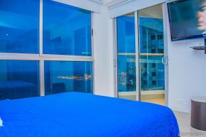 ein Schlafzimmer mit einem blauen Bett und einem großen Fenster in der Unterkunft Beach front Apartament in Cartagena de Indias