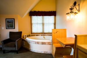 a bathroom with a tub and a chair and a table at Appenzell Inn in Estes Park +82 photos