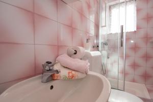 a pink bathroom with a tub and a sink at Apartment Ketty in Mošćenička Draga