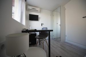 um quarto branco com uma secretária e uma cadeira em Chesscom Guesthouse em Budapeste