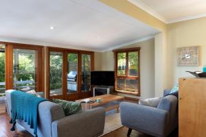 a living room with two chairs and a table at Noosa Beachhouse in Noosa Heads
