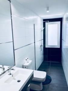 Baño blanco con lavabo y espejo en Apartamento El Reloj 1, en Los Llanos de Aridane