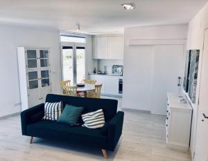 a living room with a blue couch and a kitchen at Apartamento El Reloj 1 in Los Llanos de Aridane