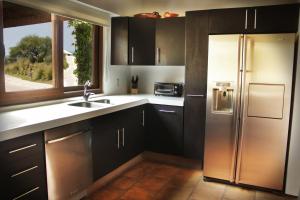 a kitchen with black cabinets and a stainless steel refrigerator at Casa Toscana - Coronado 18 in San Miguel de Allende +16 photos