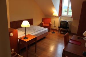 een hotelkamer met een bed, een bureau en een stoel bij Malteser Kommende in Engelskirchen +18 foto's