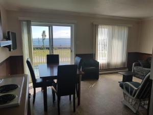 a living room with a dining room table and chairs at Motel & Chalets Baie de Gaspé in Gaspé