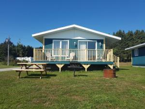 a blue house with a picnic table in front of it at Motel & Chalets Baie de Gaspé in Gaspé
